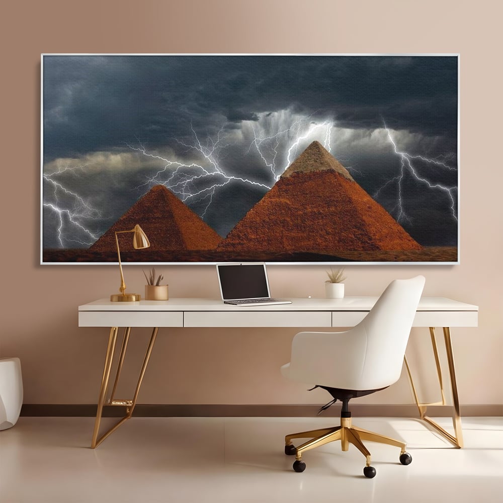 Tablou canvas cu ilustratie cu piramide si fulgere, in rama de aluminiu argintiu, pe perete intr-un birou